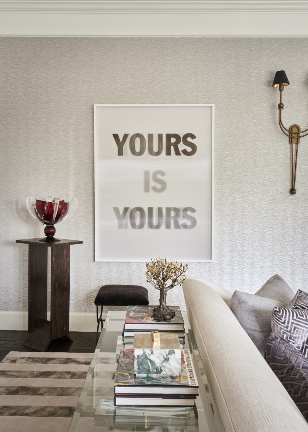 Detail shot of the living room with a Edition Modern pedestal table and Design Frères​ stool next to Hank Willis Thomas's text art.