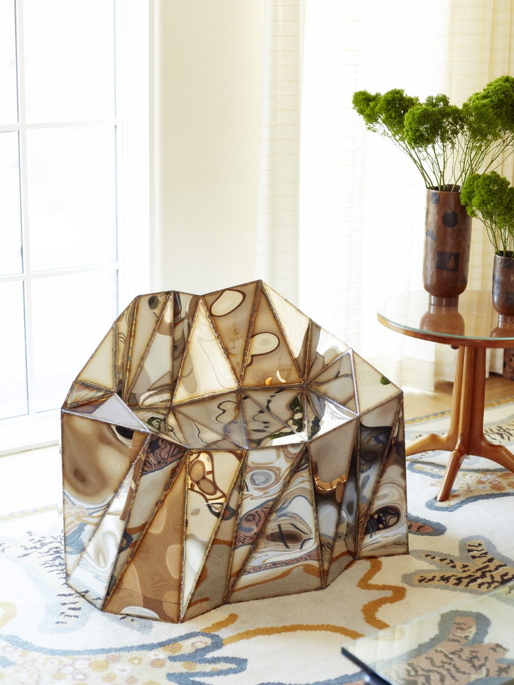 British artist Julian Mayor’s faceted metallic Glenda chair trips the light fantastic in front of a living room window in a home in Brooklyn's Gravesend neighborhood with interior design by Eli Dweck 