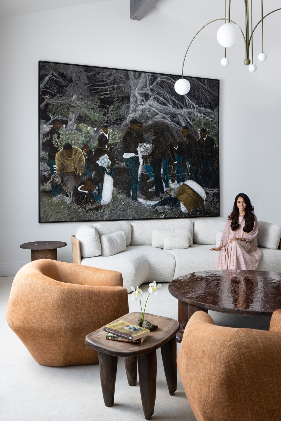 Interior designer Valerie Peña seated on a wood-framed white contemporary sofa in the living room of a house she designed in Jackson Hole, Wyoming