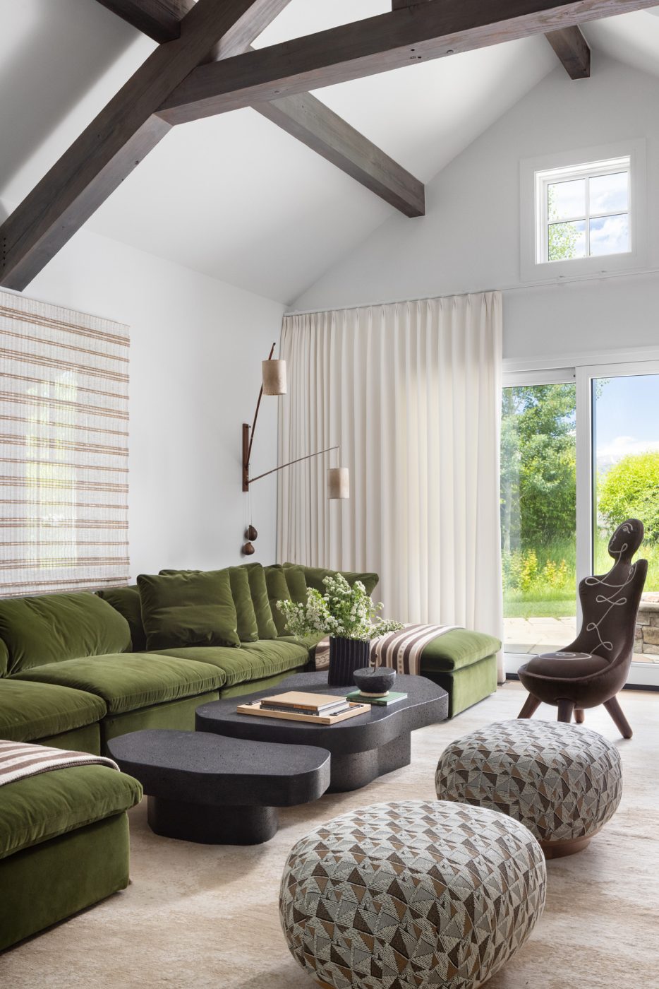 Large green sectional sofa and figurative anthropomorphic chairs in the den of a ranch house with interiors designed by Valerie Peña in Jackson Hole Wyoming