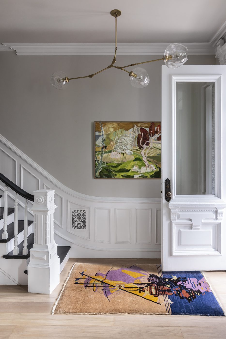 In the foyer, Studio SFW introduced color and intrigue in the form of a Lindsey Adelman three-branch Bubble chandelier, an Art Deco rug featuring a Chinese sailing vessel and the artwork Descendant of Cubist, 2019, by Dai Ban.
