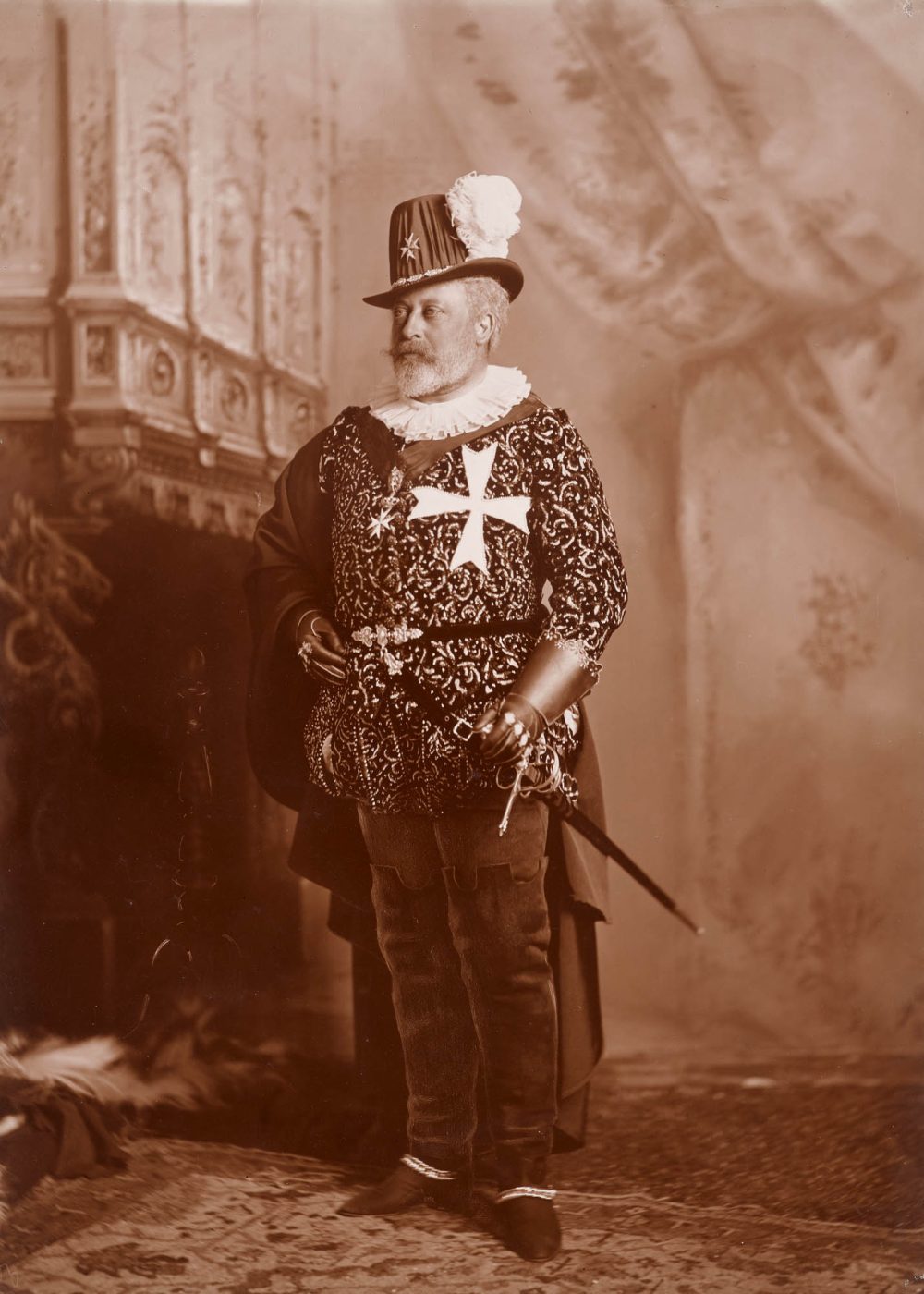 A sepia-tone photograph of King Edward VII in a 16th-century costume at a fancy-dress ball