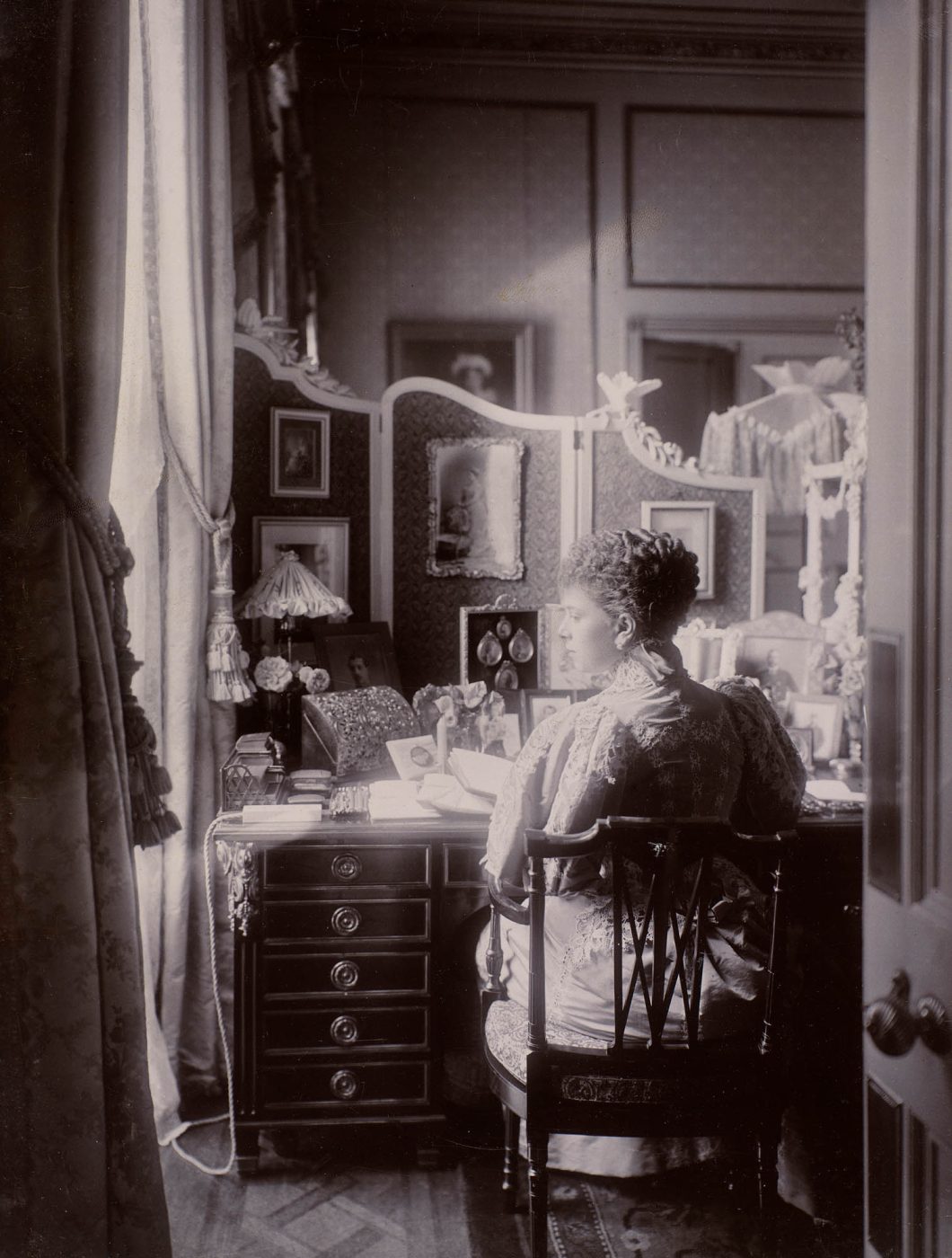A black-and-white photo of Mary, Duchess of York, sitting at her desk