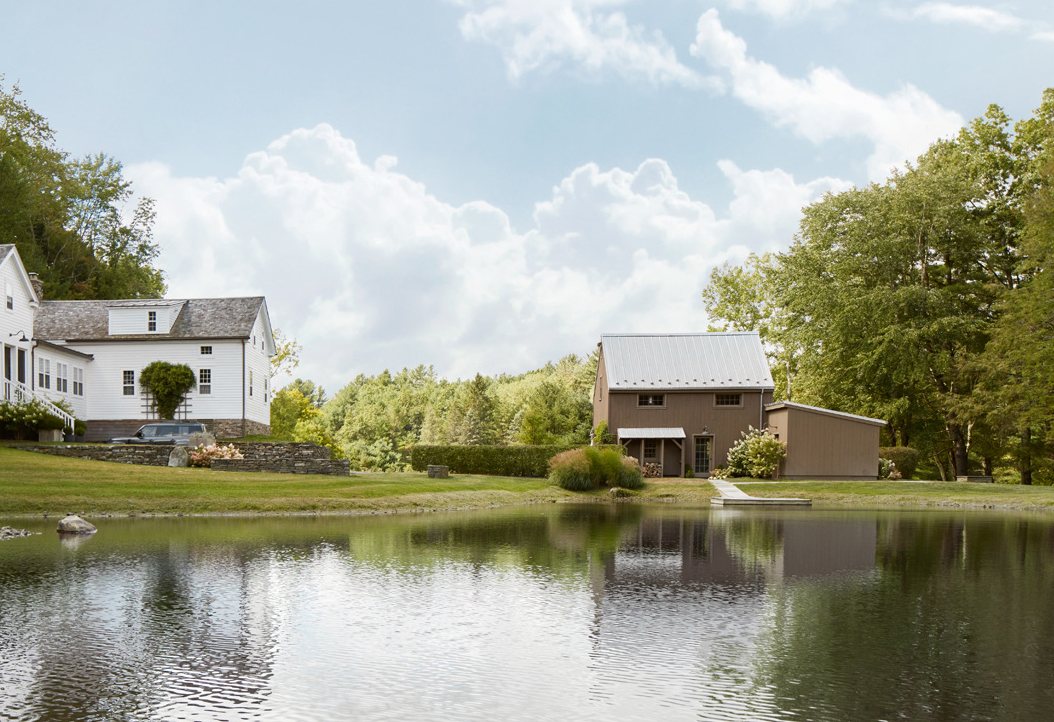 The 1830 eyebrow colonial farmhouse and its converted post-and-beam barn sit across a tranquil pond in Shawn Henderson’s compound.