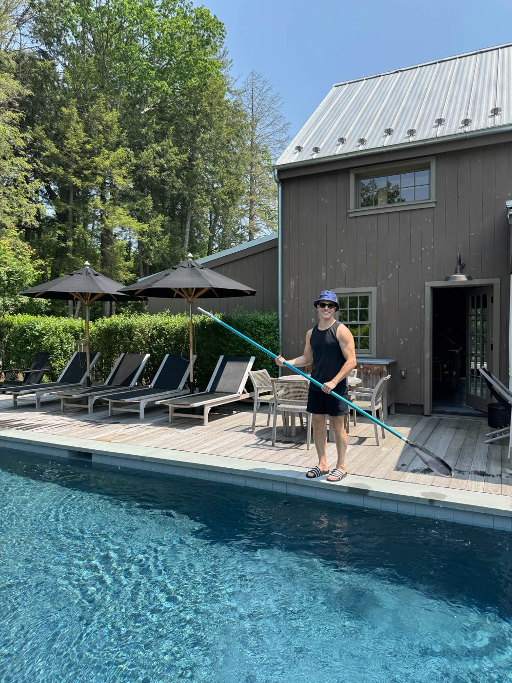 Shawn Henderson cleans the pool outside the barn suite.