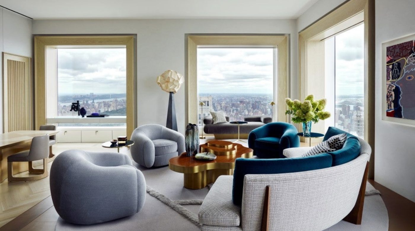 Three Jean Royère Polar Bear chairs grouped with a curved sofa and coffee table in a Manhattan high-rise apartment by William McIntosh Design
