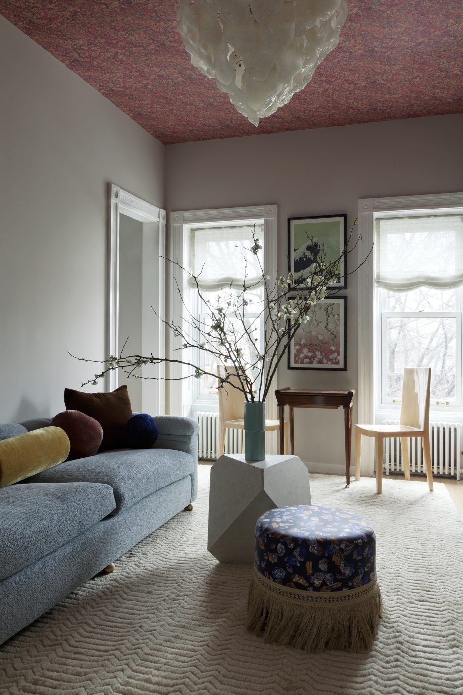 Occupying the entire top floor, the primary suite includes a sanctuary-like sitting room with such vintage furnishings as a modern low-back sofa, a 1930s Jindřich Halabala H269 armchair for Thonet and Karl Springer parchment side chairs, which are paired with a ’40s French game table next to the windows. 
