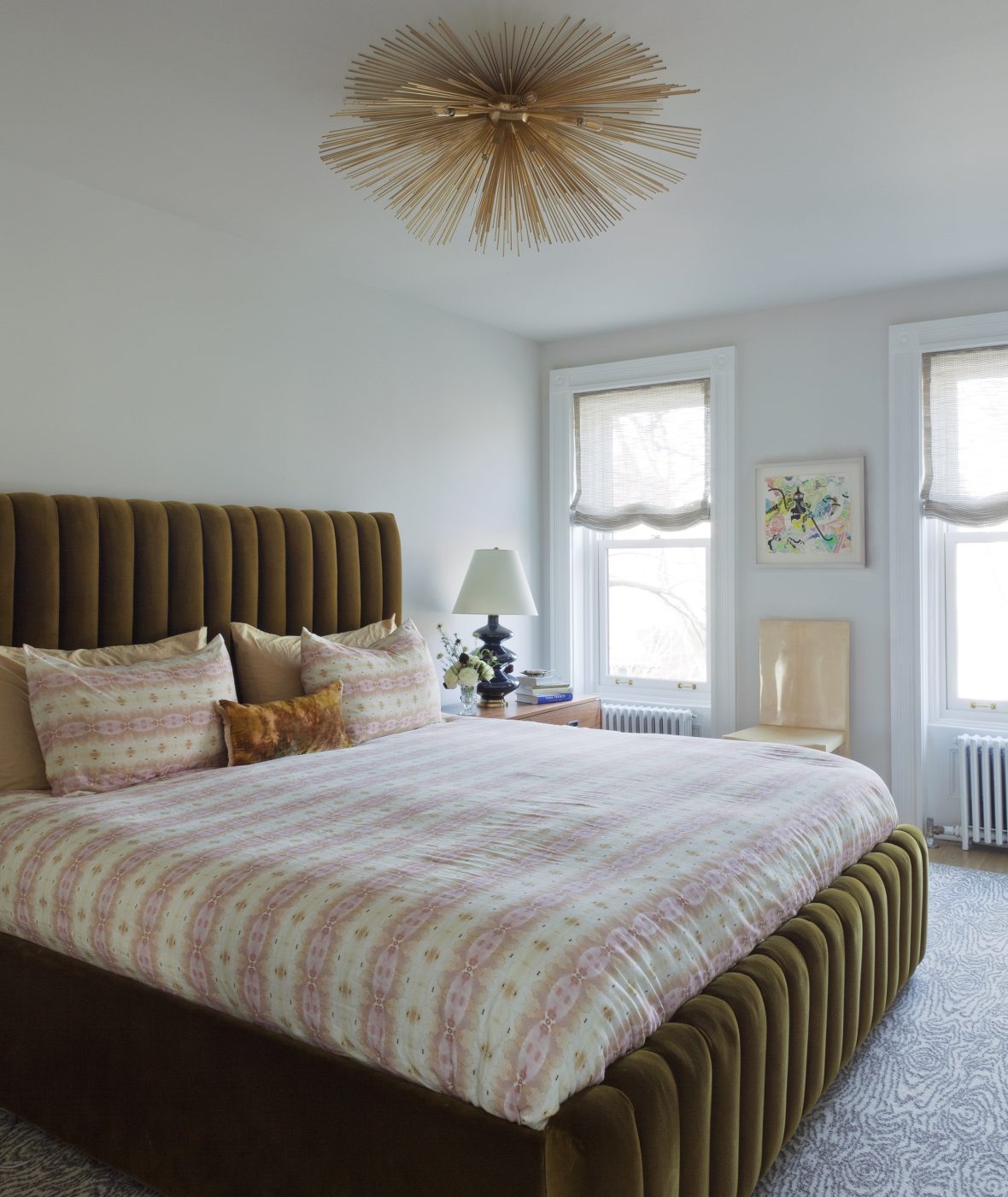 The master bedroom has a bespoke channel-tufted velvet bed features Eskayel linens, with Artifort nightstands standing on either side, while a Sputnik-style Kelly Wearstler light fixture for Visual Comfort radiates overhead.