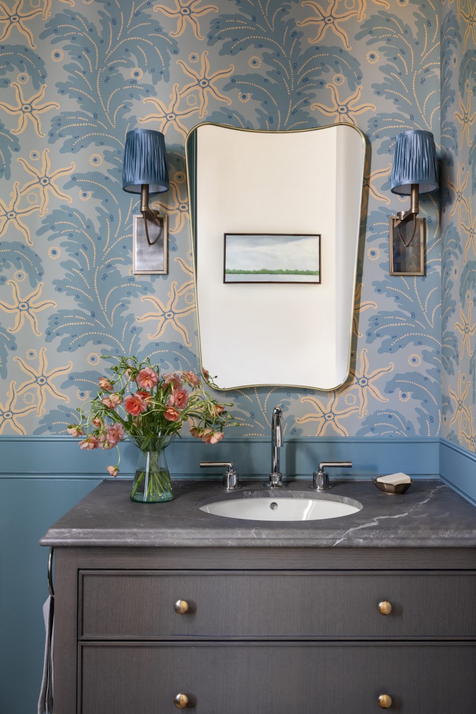 Powder room of a San Francisco row house designed by Marea Clark featuring a Gubi reedition of a mirror designed by Gio Ponti for Fontana Arte in 1933 and a wallpaper based on a French Art Deco and Wiener Werkstätte patterns from the 1910s, brass sconces are, once again, from Urban Electric.