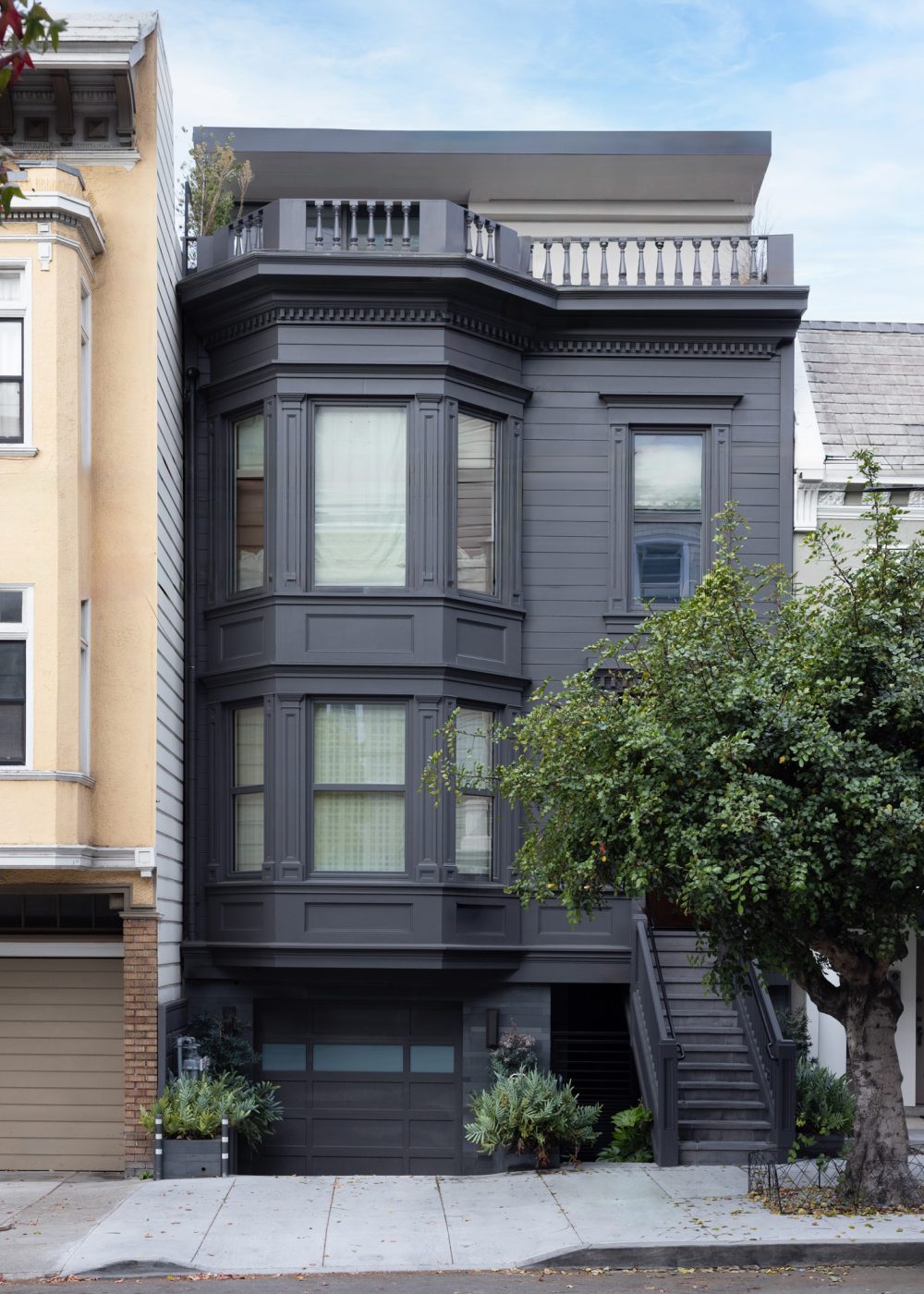 Exterior of a rebuilt Queen Anne Victorian row house on San Francisco's Russian Hill, now painted black, with interior by Marea Clark