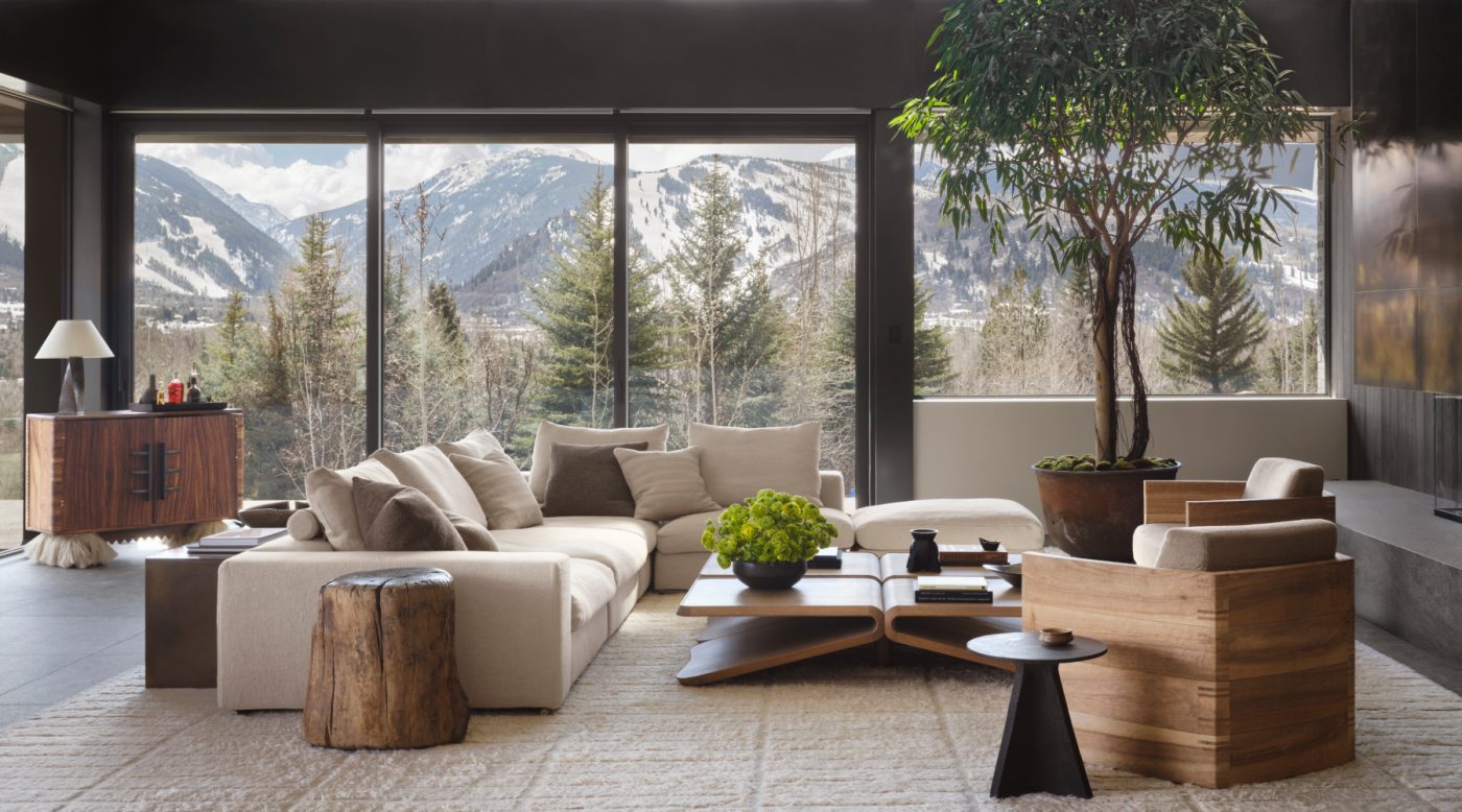 Living room of a house in Aspen, Colorado, designed by Vanessa Alexander and featuring a custom off-white sectional, a pair of Pierre Yovanovitch chairs, a contemporary oak coffee table, a Rick Owens vase from Pavillion Antiques. In the back left corner is a Cabinet Carmen by Comité de Proyectos from Galerie Philia