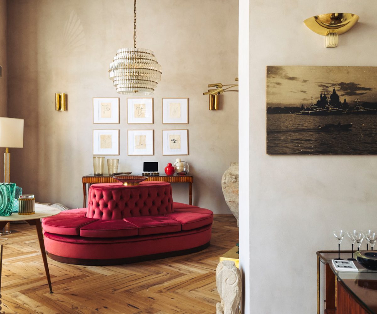 The main rooms of Italian Collector, the Florence Italy shop of antiques dealer Bec Astley Clarke, filled with mostly mid-century-modern Italian antiques, including a bright pink circular sofa and large crystal chandelier