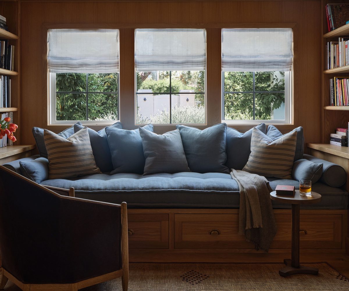 Library of Malibu California home of interior designer Sarah Solis featuring custom French-oak millwork and a Galerie Solis Crowne chair and a built-in daybed.