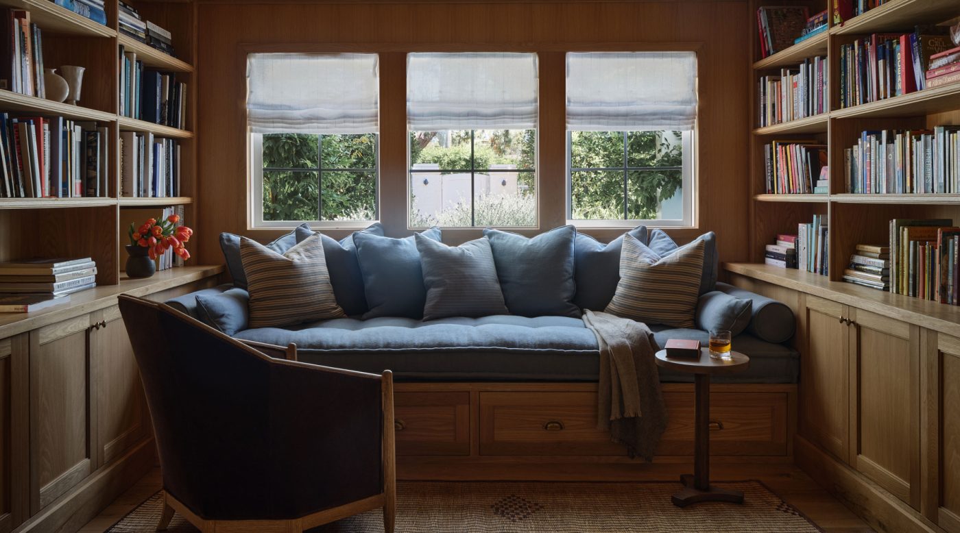 Library of Malibu California home of interior designer Sarah Solis featuring custom French-oak millwork and a Galerie Solis Crowne chair and a built-in daybed.