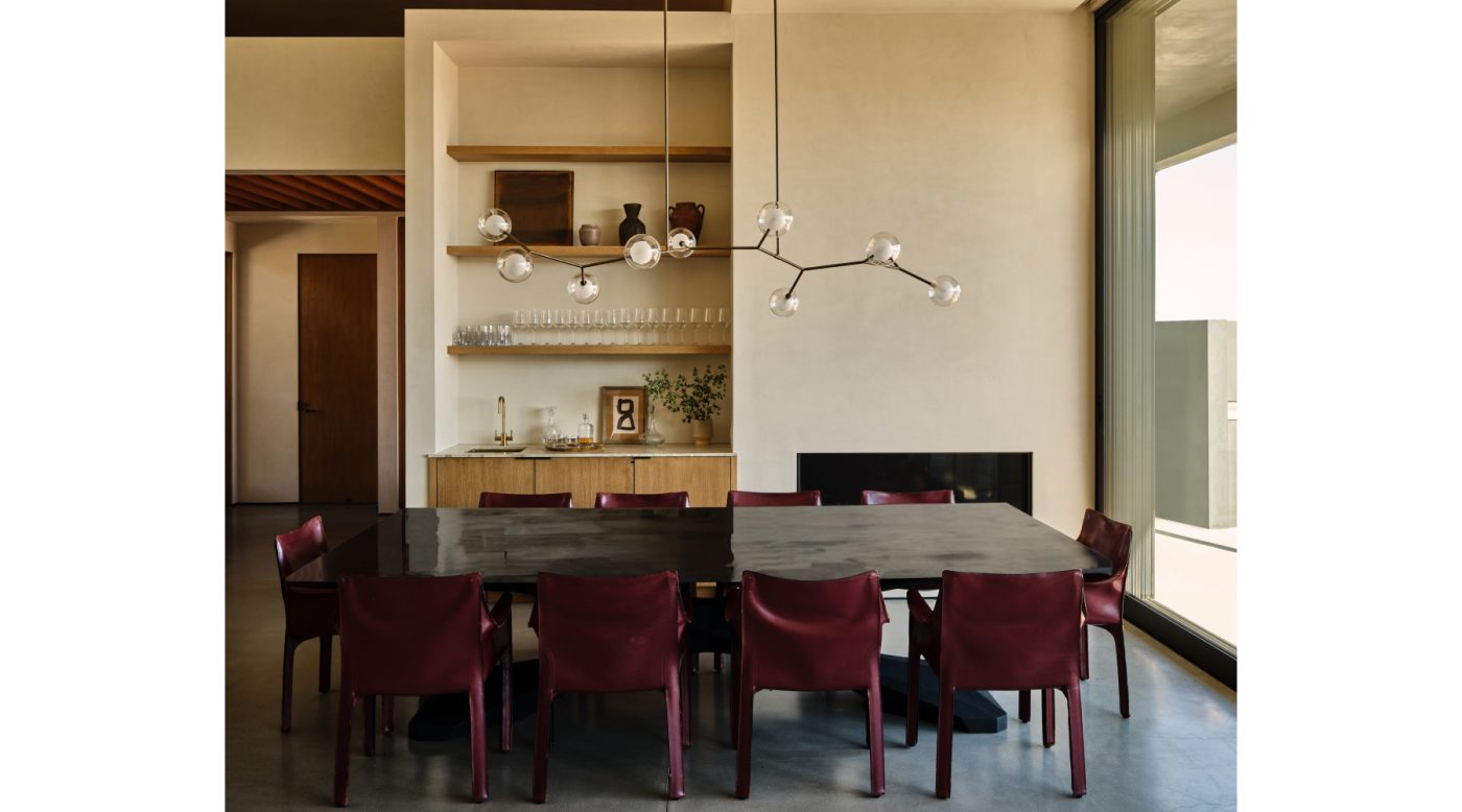 Dining area in great room of Malibu California home of NFL player Baltimore Ravens Ronnie Stanley designed by Sarah Solis featuring a Giffin Design branching chandelier over a set of Mario Bellini’s Cab chairs surrounding a custom dining table