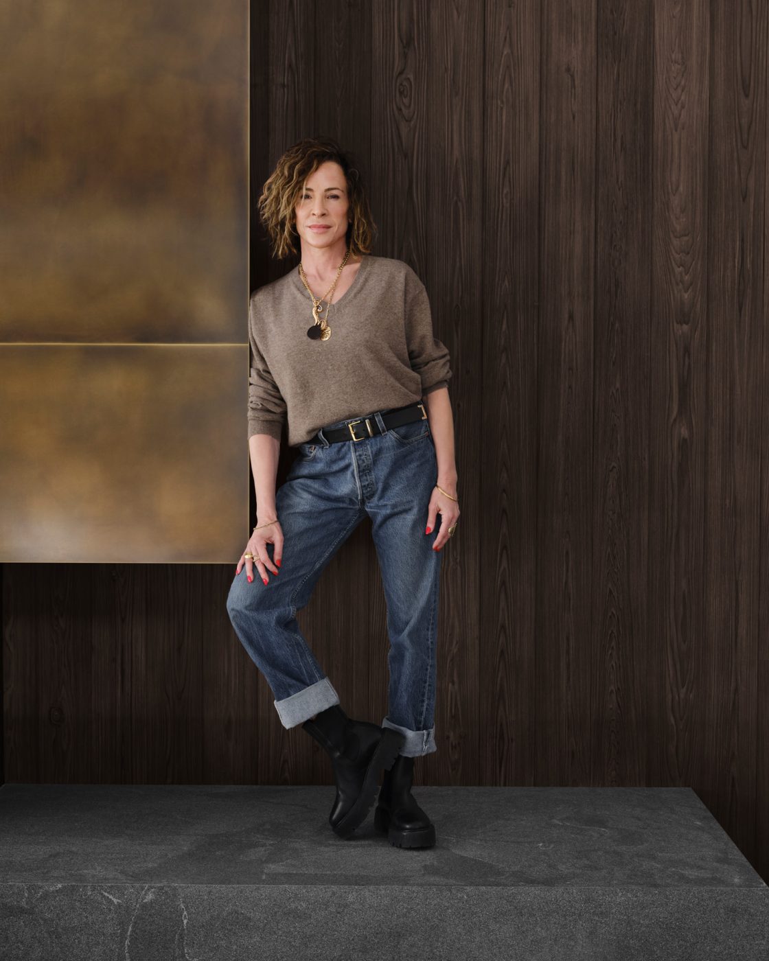 Interior designer Vanessa Alexander portrait in jeans and v-neck sweater tucked in photographed in a house she designed in Aspen, Colorado