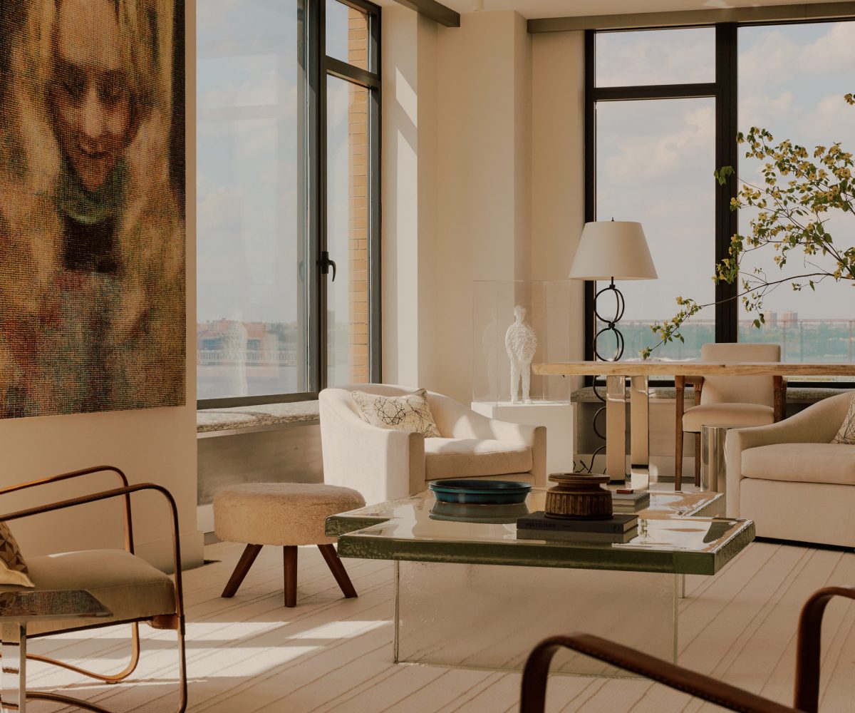 Living room in nearly all white minimalist loft apartment in New York's West Village designed by Clive Lonstein and featuring Jacques Adnet armchairs, a cast-glass coffee table from Lonstein's new furniture collectio and a large ceramic table lamp attributed to the Swedish maker Rörstrand