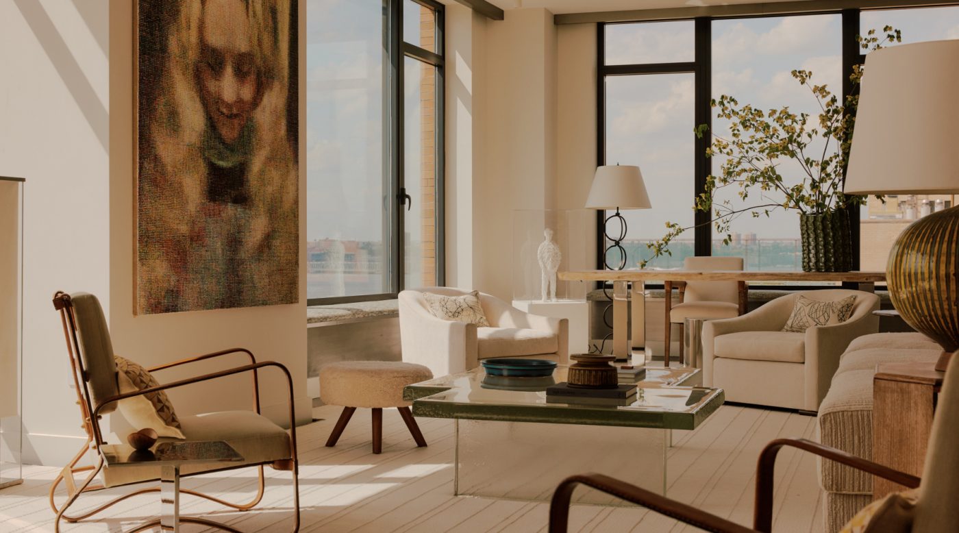 Living room in nearly all white minimalist loft apartment in New York's West Village designed by Clive Lonstein and featuring Jacques Adnet armchairs, a cast-glass coffee table from Lonstein's new furniture collectio and a large ceramic table lamp attributed to the Swedish maker Rörstrand