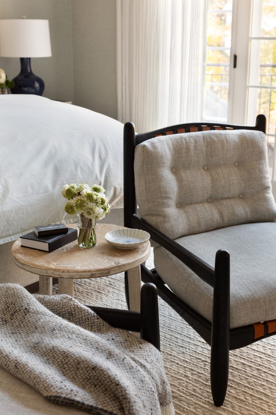 Armchair at foot of bed in primary bedroom of Glencoe Illinois home redesigner by interior designer Andrea Goldman 
