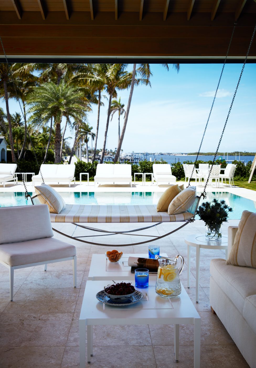 Loggia with pool and intracoastal waterway beyond at West Palm Beach house with architecture by Daniel Kahan of Smith and Moore Architectures and interiors by Caroline Rafferty