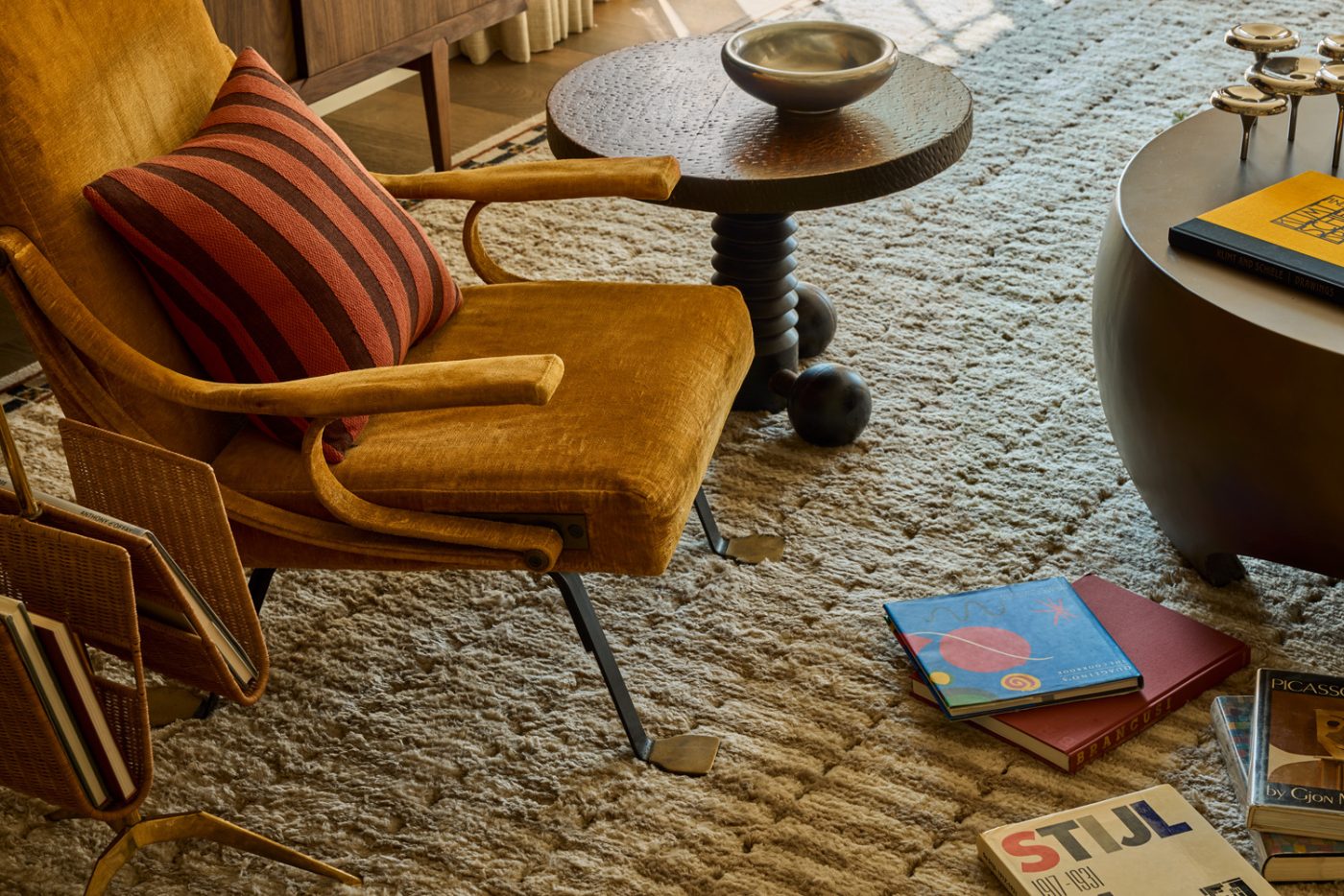 Zak + Fox wool rug, Charles Dudouyt sidetable, art books and Ignazio Gardella reclining chair in the living room of a 1912 Colonial-style home redesigned by Autumn Oser and Andre Golsorkhi, partners in the design firm Haldon House