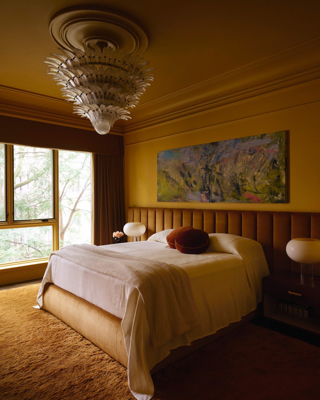 Deep yellow primary bedroom with channel-tufted headboard and Murano glass palmette chandelier in a Harlem townhouse design by Crystal Sinclair