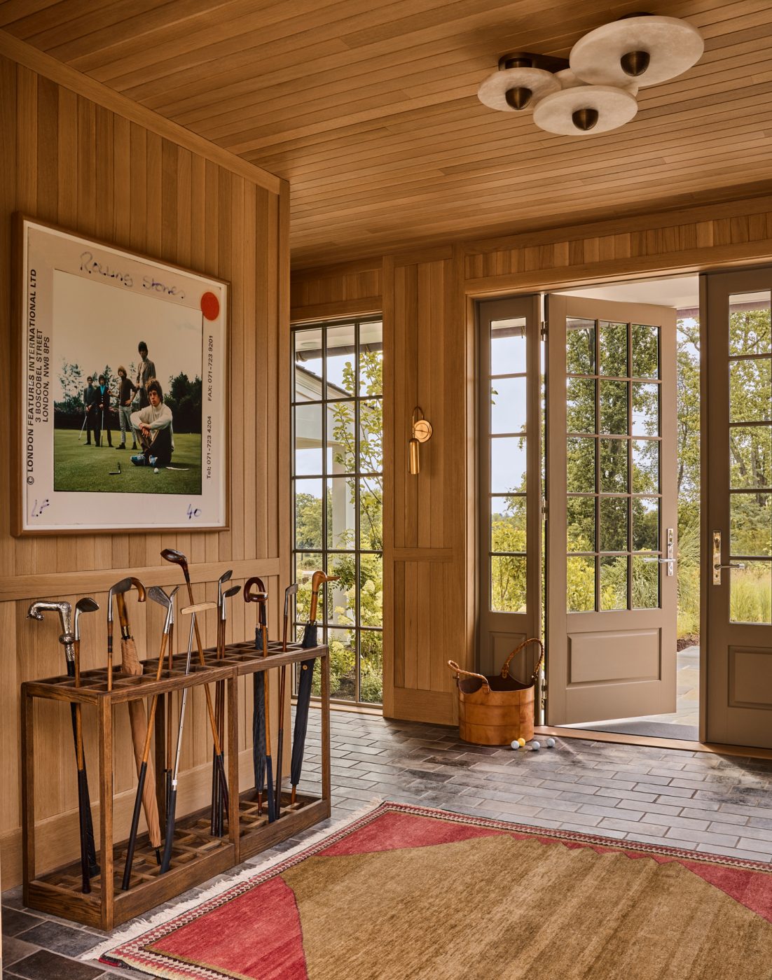Light wood-paneled entry with multipaned windows and doors of a recently finished vintage Colonial-style home redesigned by Autumn Oser and Andre Golsorkhi, partners in the design firm Haldon House