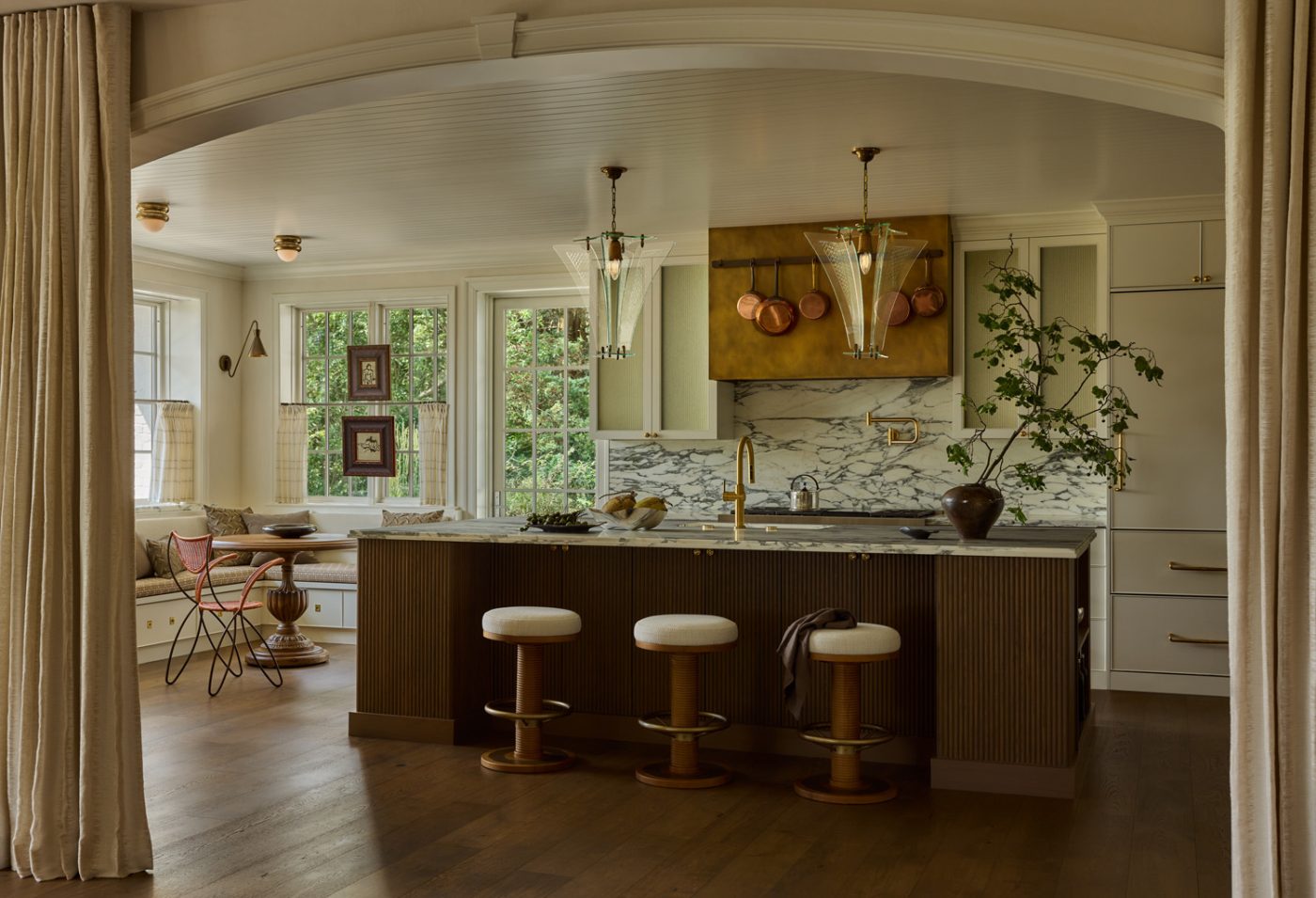 large glass 1960s pendants over the marble-topped kitchen island in kitchen of a 1912 Colonial-style home redesigned by Autumn Oser and Andre Golsorkhi, partners in the design firm Haldon House