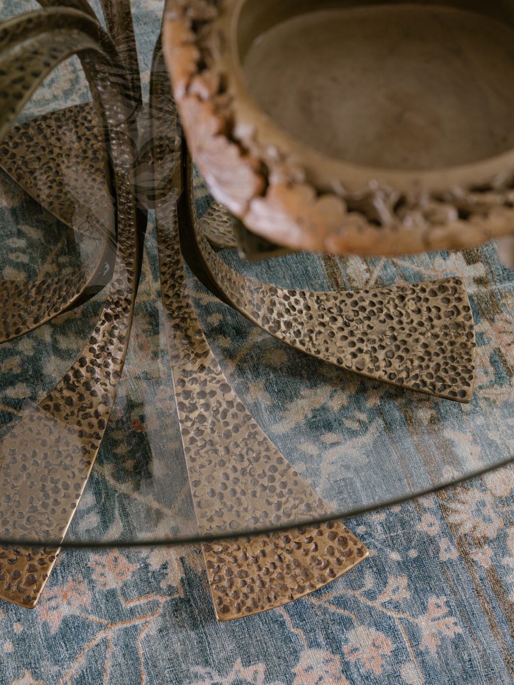 Close up birds eye view of glass-topped bronze center table in reception room of a Long Island home with interiors by studio Evan Edward designers Michael Edward Moirano and Josh Evan Goldfarb
