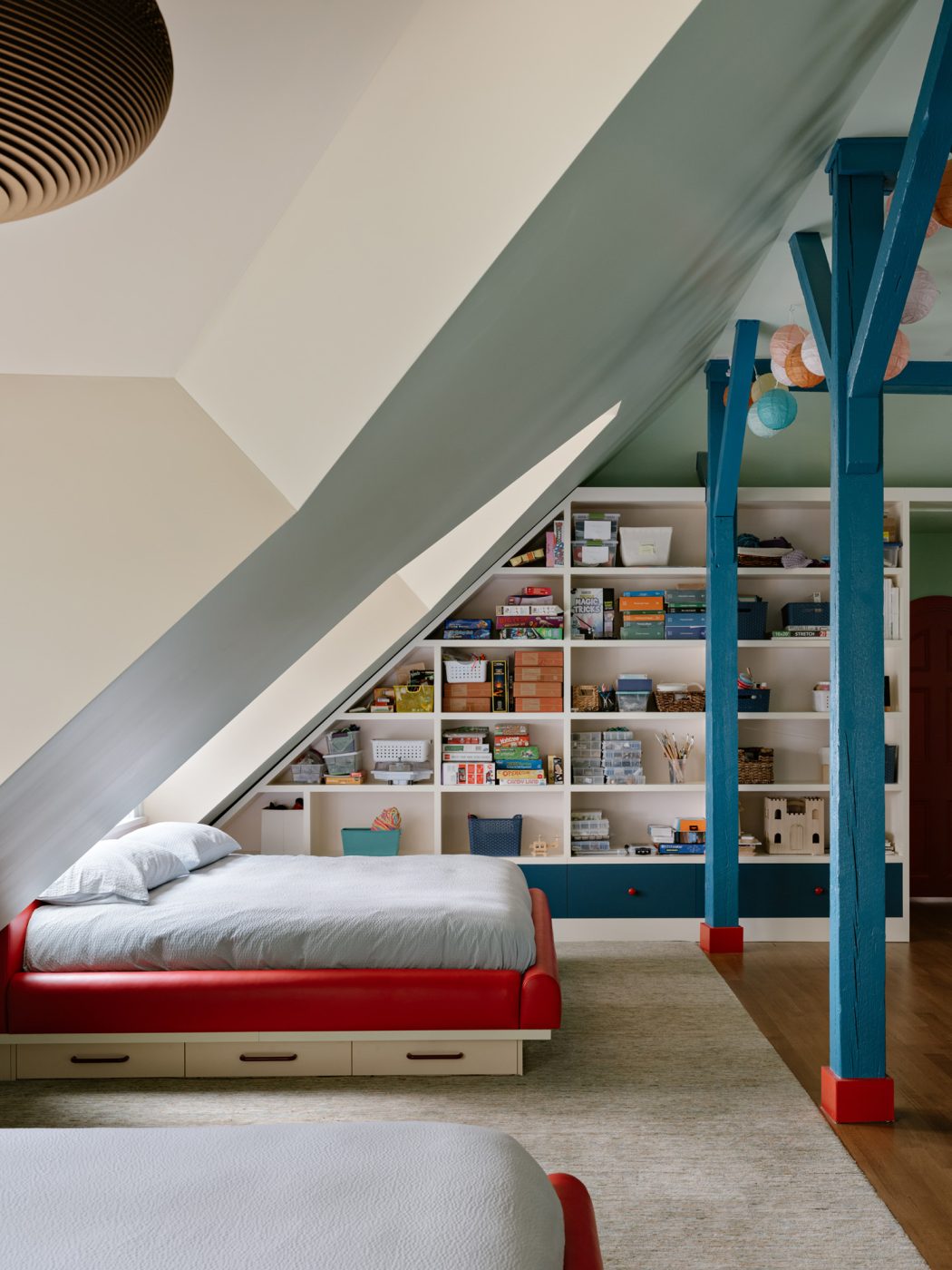King-size custom bed built into the large dormers in the top-floor bunkroom of a Long Island home with interiors by studio Evan Edward designers Michael Edward Moirano and Josh Evan Goldfarb