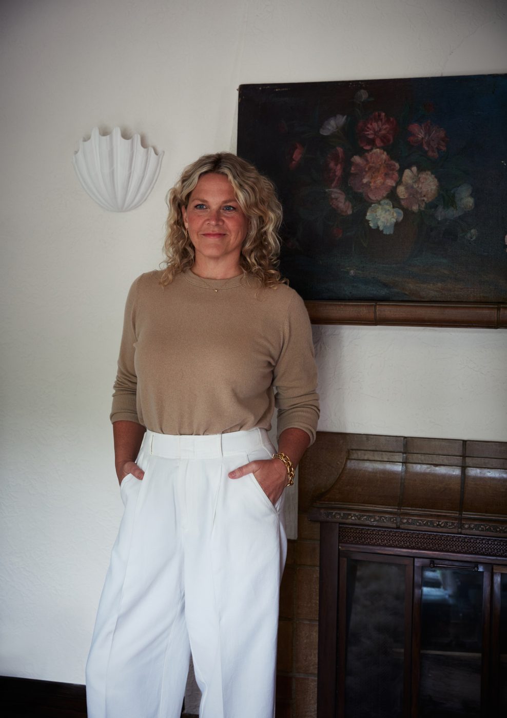 Portrait of interior designer Anne McDonald taken beside the mantel in the living room of a Mediterranean-style house in Minneapolis, Minnesota