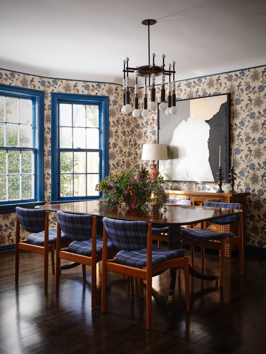 dining room with botanical wallpaper, plaid-upholsted mid-century chairs, blue window trim and dark floors in a Spanish Colonial house in Highland PArk Village Dallas designed by Dafna Kikuchi of Daf&Co