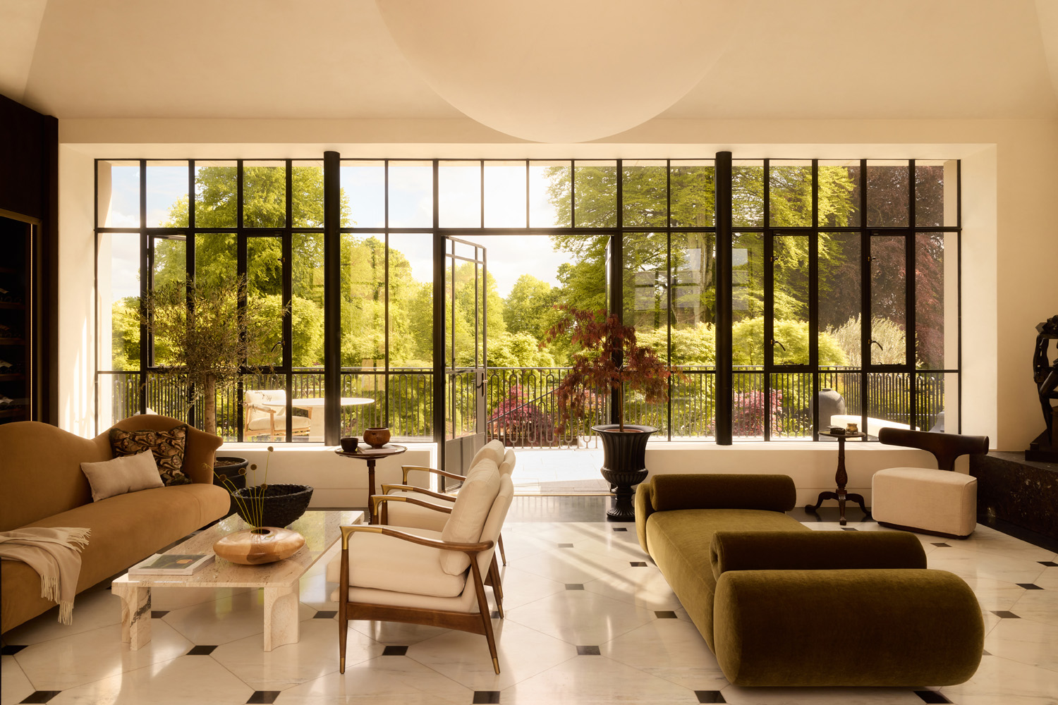 Window-walled orangerie-style newly added great room in a 19th-century Georgian-style manor house in Irish Countryside designed by Dublin-based Róisín Lafferty