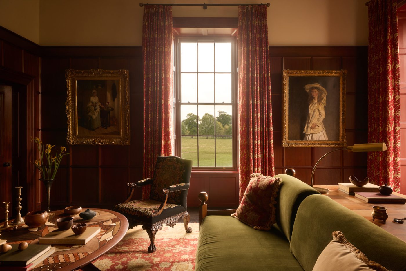 Wood paneled library with Luigi Caccia Dominioni sofa and Sir William Orpen oil portrait of a girl in a 19th-century Georgian-style manor house in Irish Countryside designed by Dublin-based Róisín Lafferty