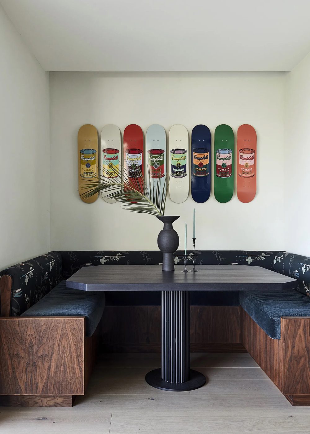 A set of Andy Warhol Tomato Soup Can boards lined up above a Los Angeles dining nook designed by Elizabeth Law.