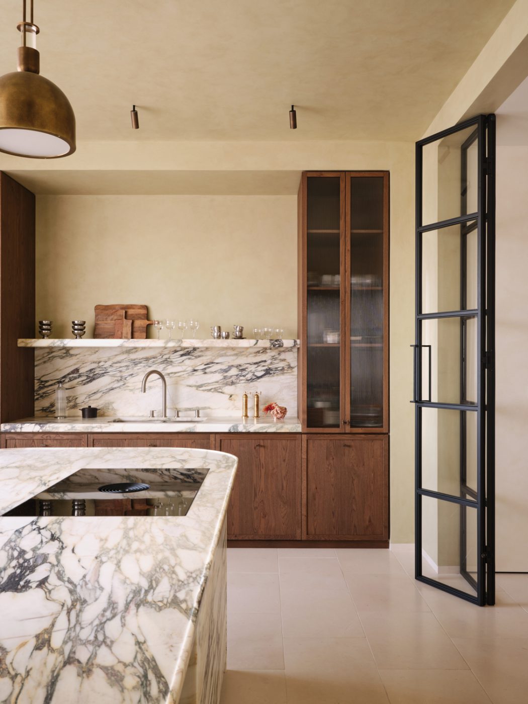 Marble and wood kitchen in in a Milan penthouse whose interiors are by Edo Mapelli Mozzi, founder of the design and development firm Banda.