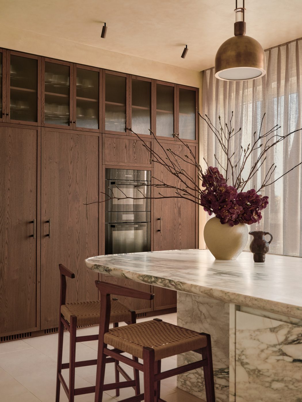 Marble and wood kitchen in in a Milan penthouse whose interiors are by Edo Mapelli Mozzi, founder of the design and development firm Banda.