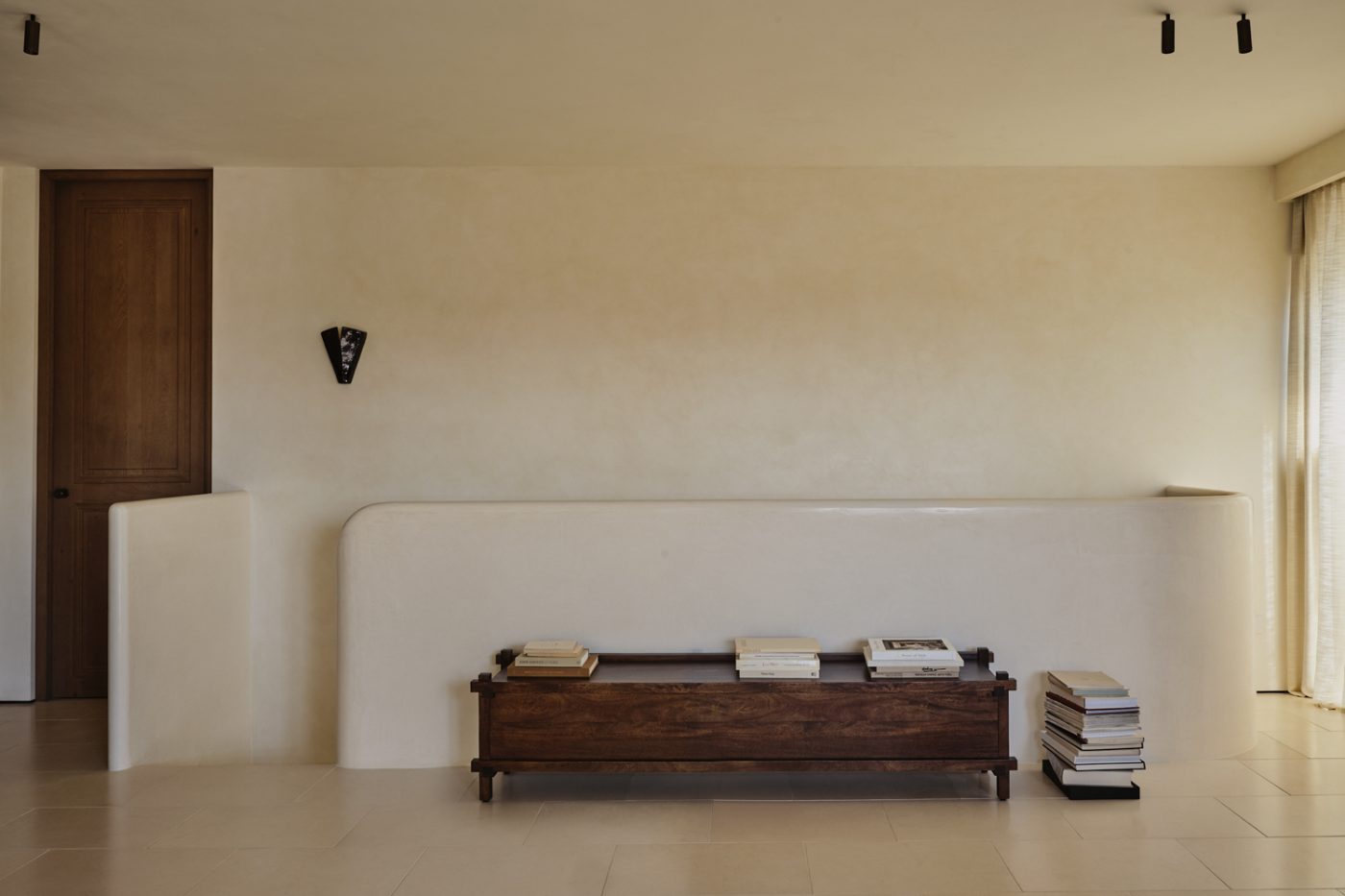Serene upper stair landing with plaster walls and tiled floor in a Milan penthouse whose interiors are by Edo Mapelli Mozzi, founder of the design and development firm Banda.