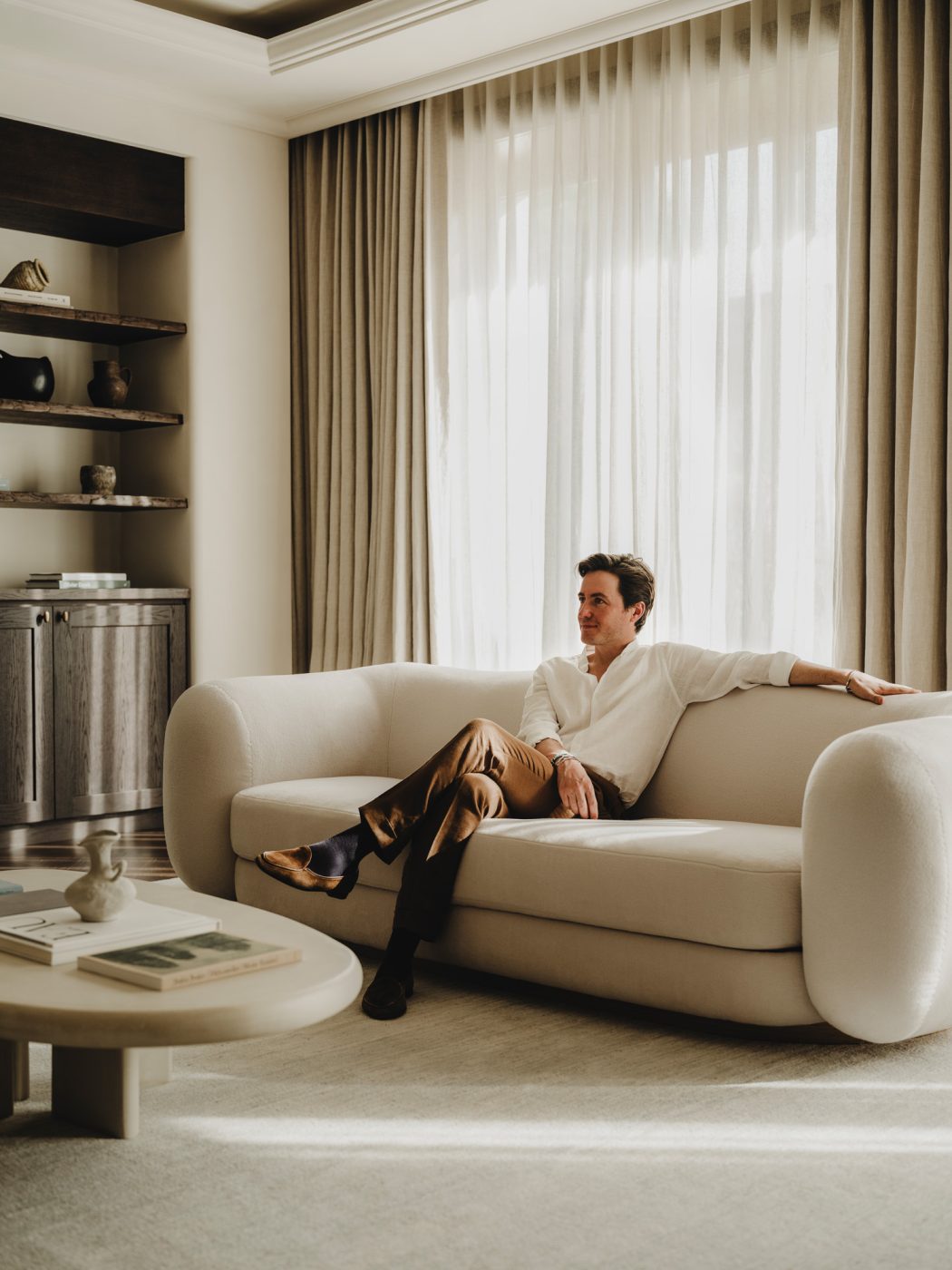Portrait of Edo Mapelli Mozzi, founder of the design and development firm Banda, in a contemporary, neutrally hued living room.
