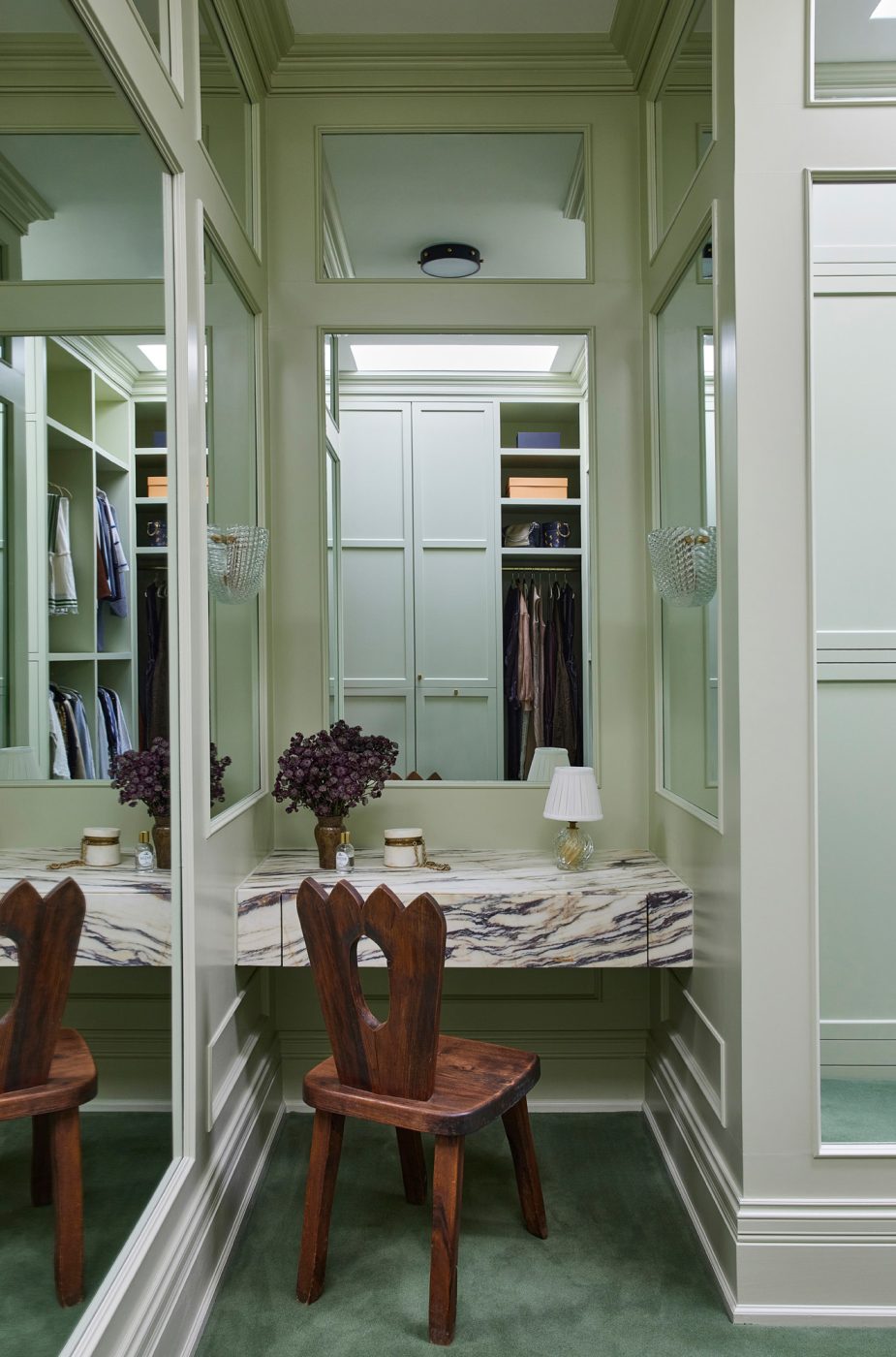 An Olavi Hanninen chair, Calacatta Viola–marble floating vanity, Barovier&Toso lamp and Art Deco–style Seguso sconces from Galeria Filamento in the dressing room in the primary suite of a historic Chicago townhouse by design partners Laura Buxbaum Gordon and Nate Berkus