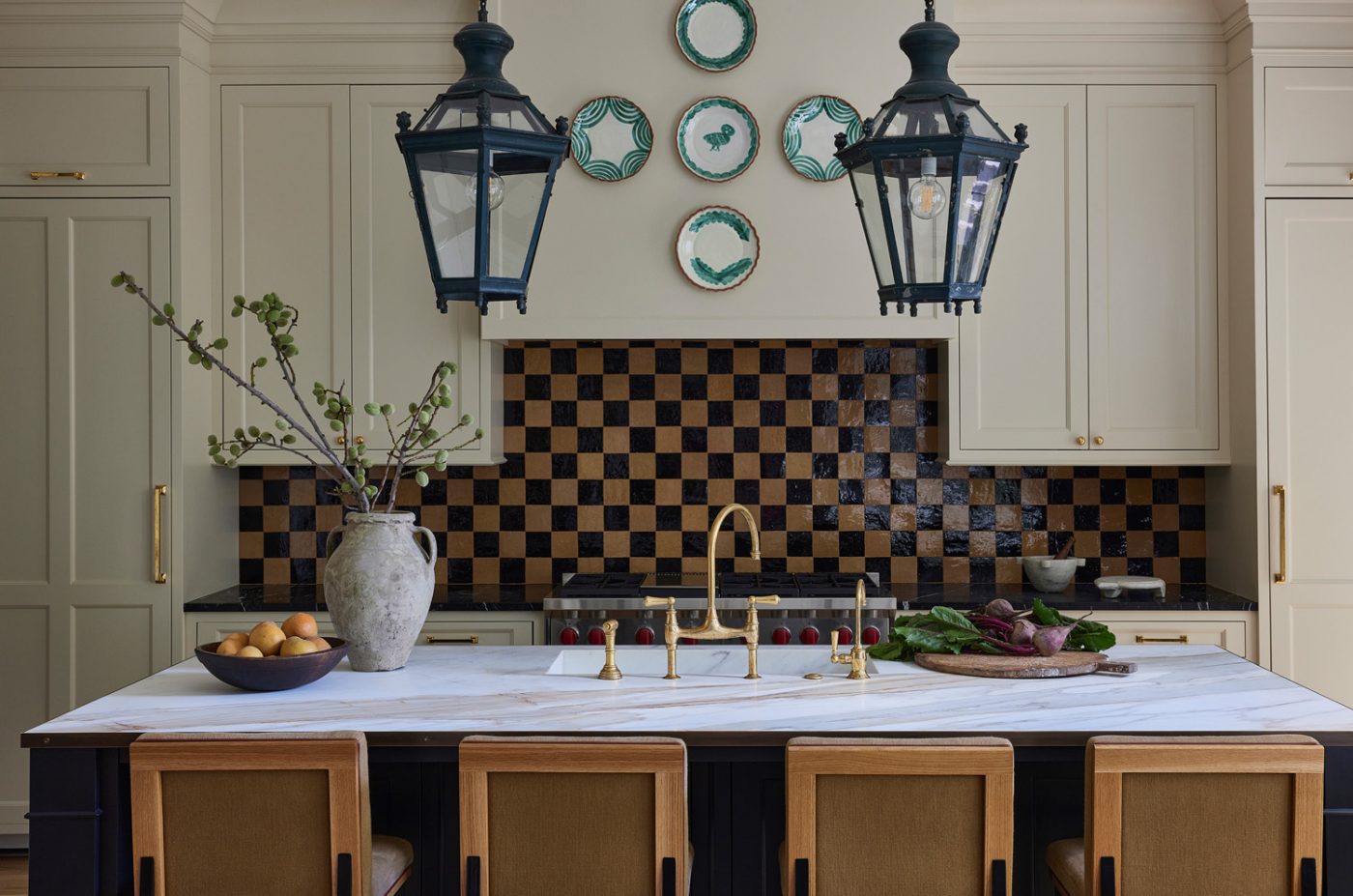 Italian lanterns from Obsolete dangle over the Macchia Vecchia–marble-topped island in the kitchen of a historic Chicago townhouse by design partners Laura Buxbaum Gordon and Nate Berkus