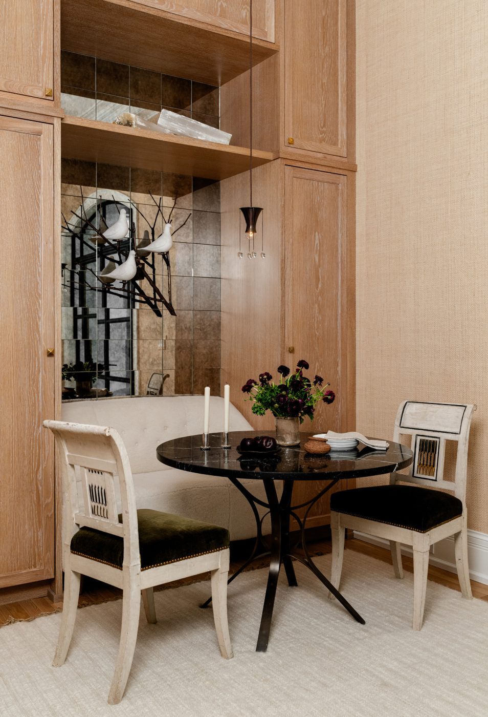 Directoire chairs pull up to a Roger Sprunger table in the sitting room/wine lounge of a historic Chicago townhouse by design partners Laura Buxbaum Gordon and Nate Berkus