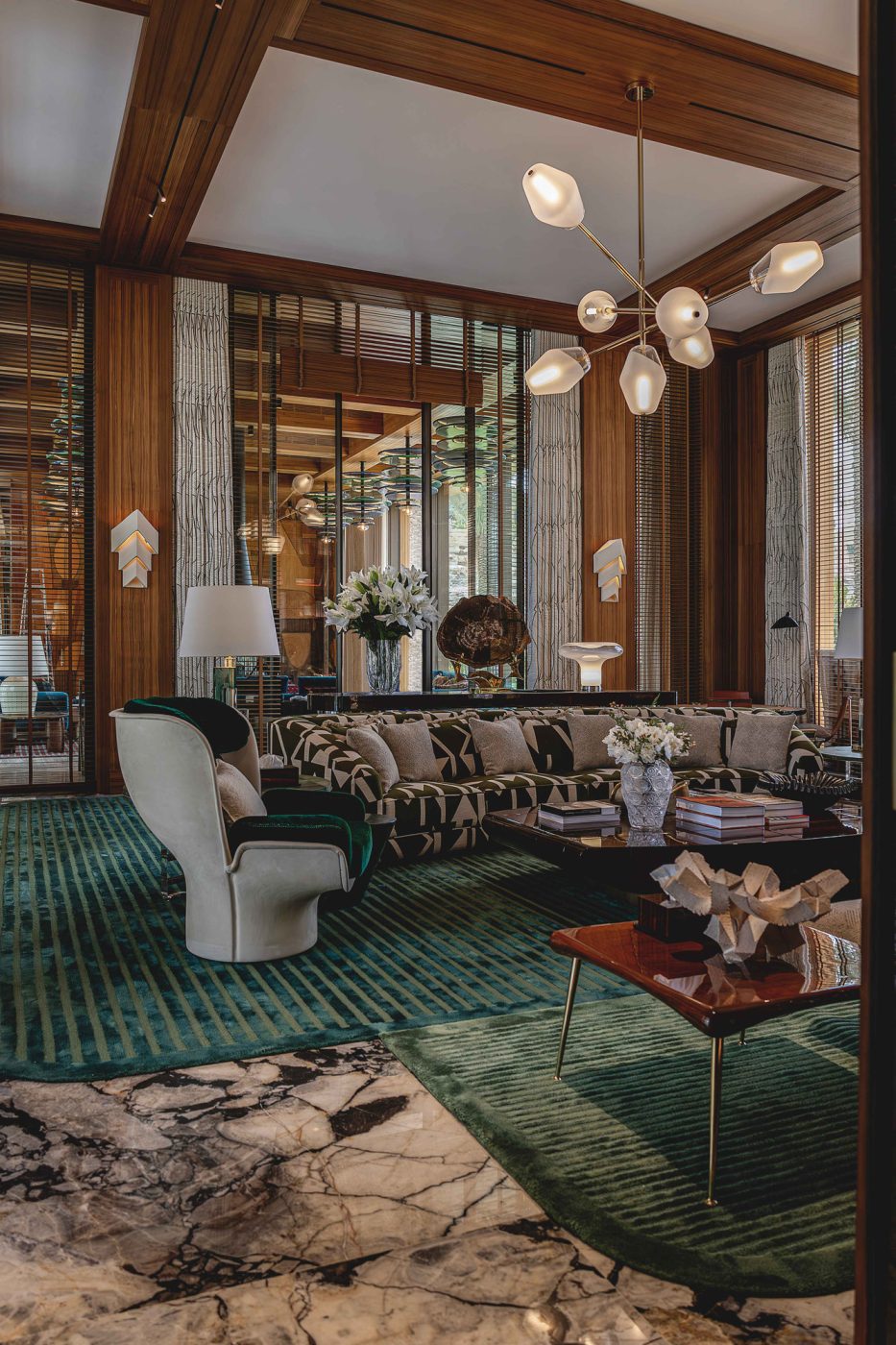 A Régis Botta chandelier lights and Guy Bareff sconces illuminate the game room of the entertaining pavilion on a large compound in Saudi Arabia by Jacques Bec and Artur Miranda's architecture and design studio Oitoemponto