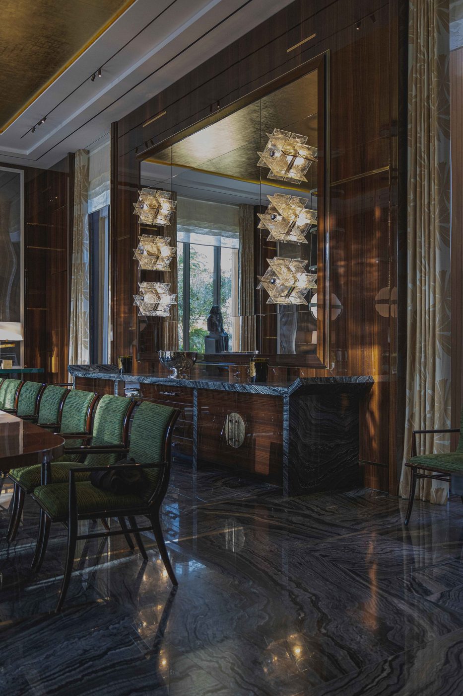 J.T. Kalmar sconces over buffet tables with tops with upturned eges inspired by traditional Chinese furniture in the dining room of the entertaining pavilion on a large compound in Saudi Arabia by Jacques Bec and Artur Miranda's architecture and design studio Oitoemponto