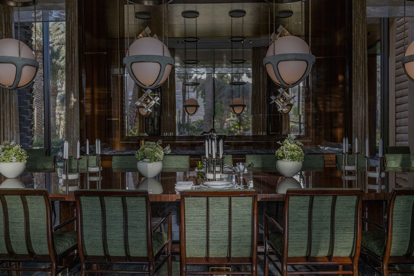 T.H. Robsjohn-Gibbings chairs from Modern Epic Antiques and Apparatus pendant lights above the table in the dining room of the entertaining pavilion on a large compound in Saudi Arabia by Jacques Bec and Artur Miranda's architecture and design studio Oitoemponto