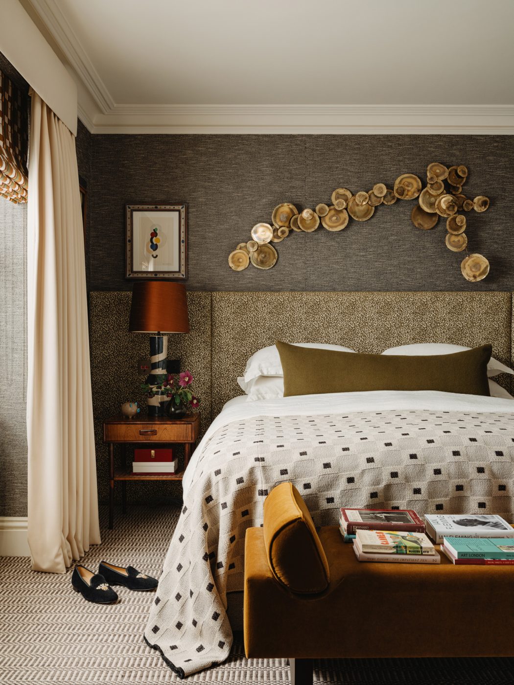 Primary bedroom with Curtis Jere wall sculputre and in the apartment in London's Kensington owned and decorated by Romanos Brihi, co-founder of the London interior design firm Studio Vero