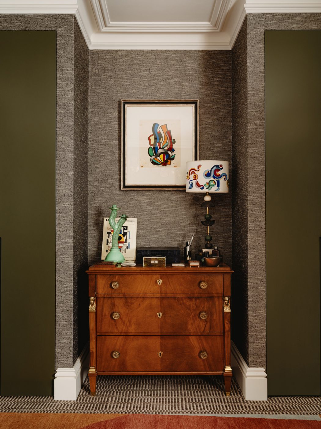 a Fernand Léger gouache hung over over a 19th-century French Empire chest of drawers in the Primary bedroom of the apartment in London's Kensington owned and decorated by Romanos Brihi, co-founder of the London interior design firm Studio Vero