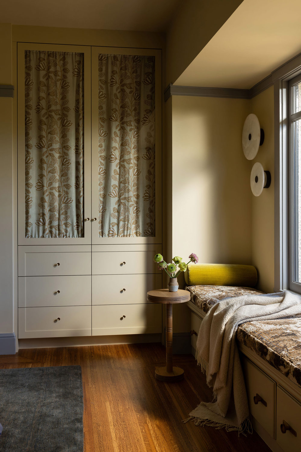 Window seat and built-in stoprage cabinet in primary bedroom of Craftsman-style house in San Francisco's Presidio designed by Katie Troutman