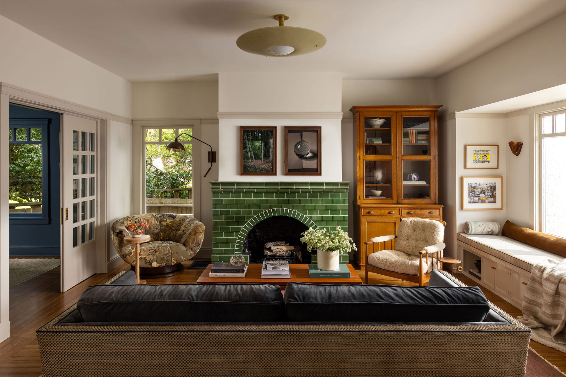 Living room of Craftsman-style house in San Francisco's Presidio designed by Katie Troutman featuring ab Adrian Pearsall chair, an Allied Maker light, a glass-fronted 19th-century Staffordshire bookcase