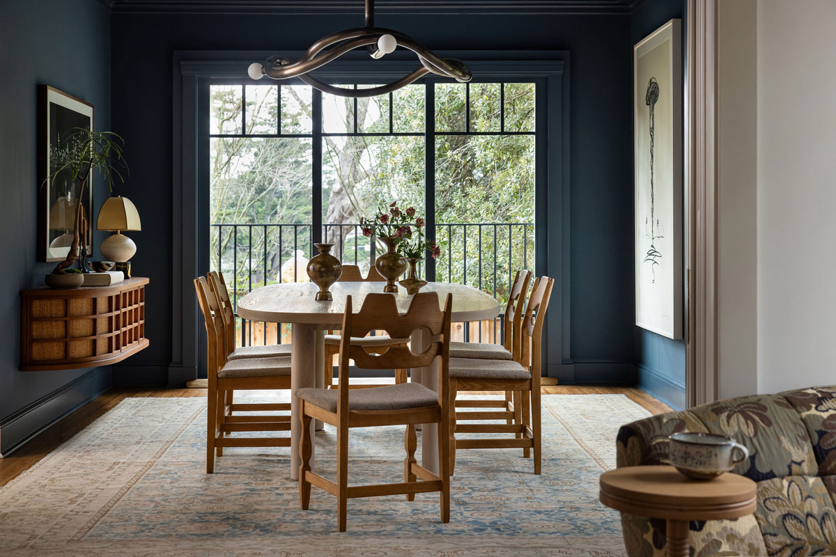 Dining room of Craftsman-style house in San Francisco's Presidio designed by Katie Troutman and featuring Henning Kjærnulf Razorblade chairs at a table atop an antique Persian Malayer rug under a chandelier by Paul Matter